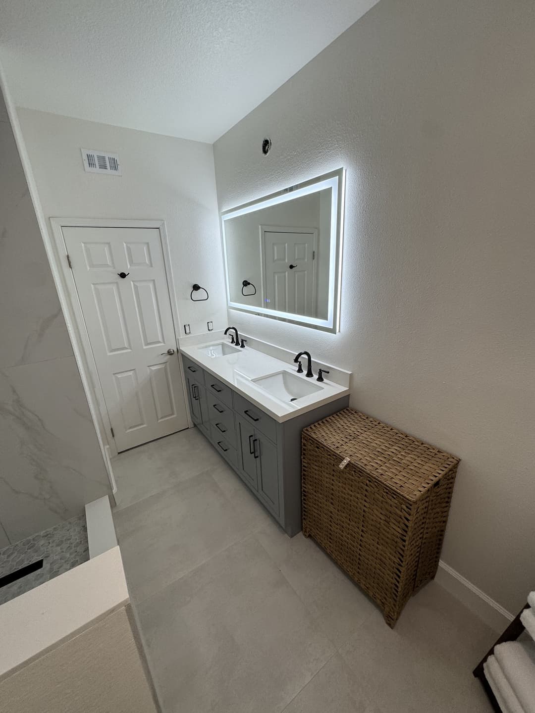 Residential bathroom renovation featuring double sink vanity and storage cabinetry