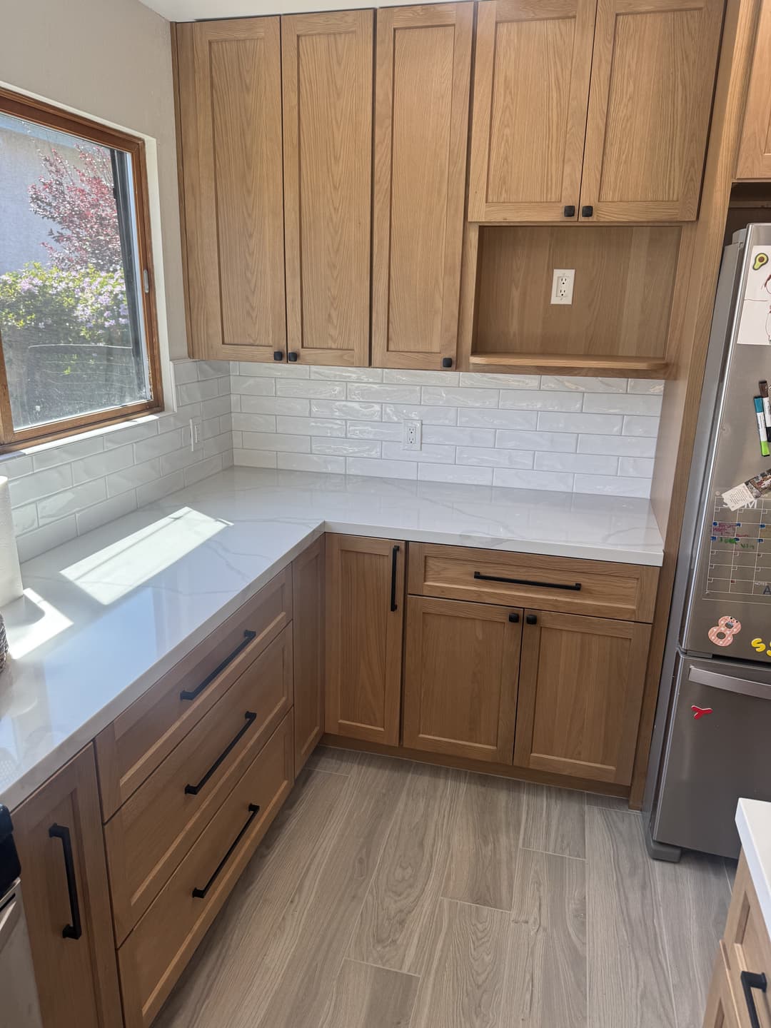 Kitchen remodel showcasing wood cabinets, tile backsplash, and clean finishes